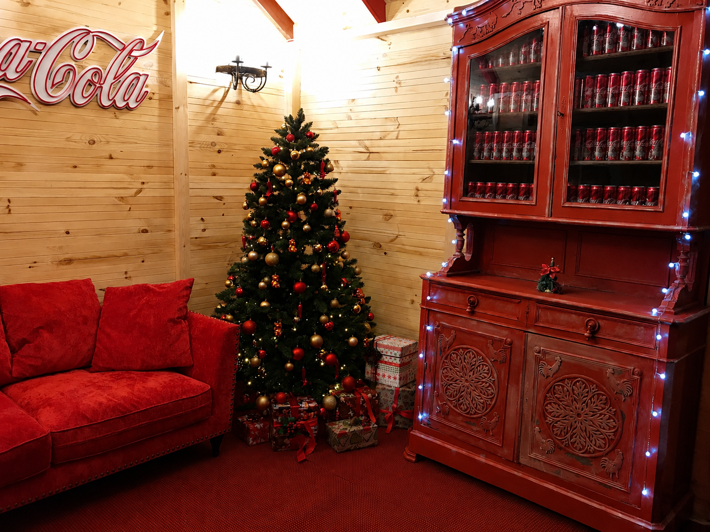 Roter Vintage-Schaukasten mit Coca-Cola-Dosen neben dem Baum