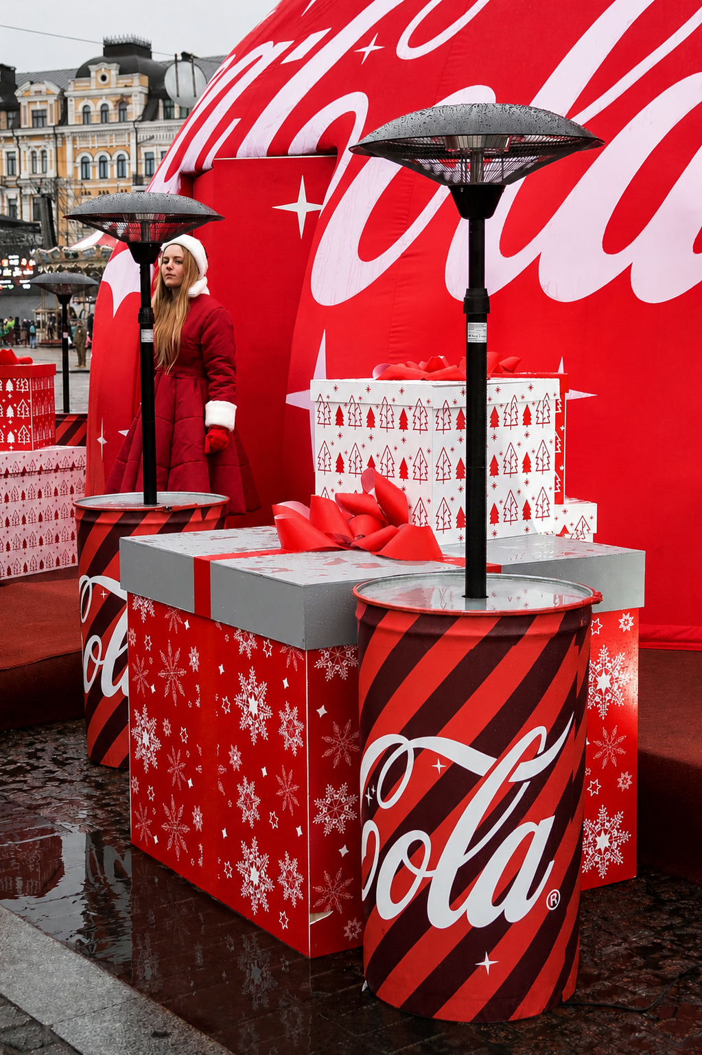 Außensitzbereich mit gebrandeten Fass-Tischen vor einer beleuchteten Coca-Cola-Kuppel