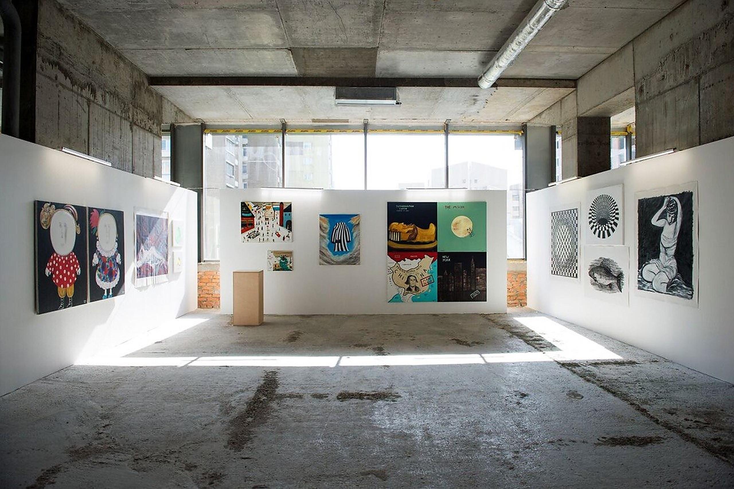 Betongalerie mit gemischten Kunstwerken um einen zentralen Sockel
